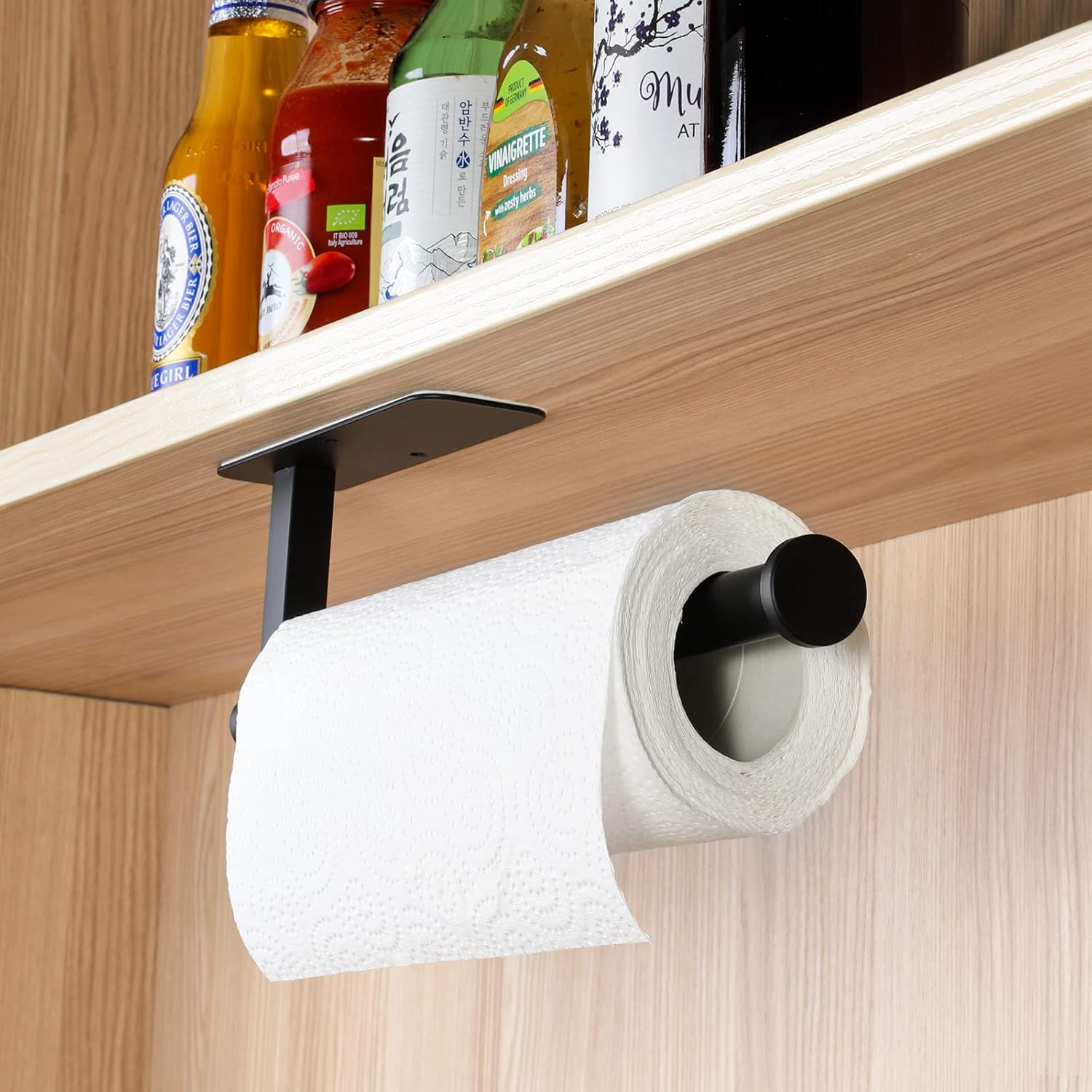 Paper towel holder mounted under a wooden shelf with bottles on it